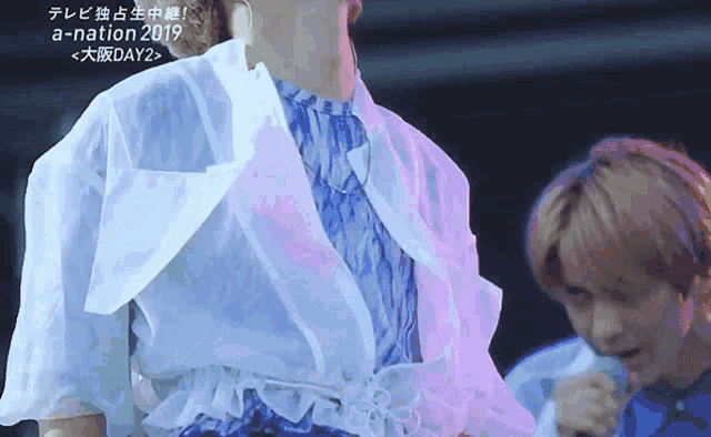 a man in a white jacket is standing next to another man in a blue shirt and the words a-nation 2019 are on the bottom