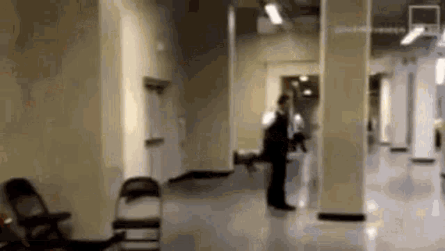 a man in a suit is standing in a hallway with a dog .