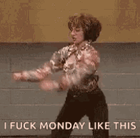 a woman is dancing in front of a brick wall while wearing headphones .