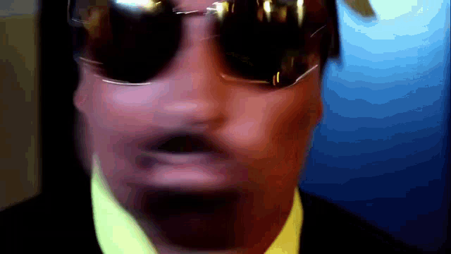 a close up of a man wearing sunglasses and a tie