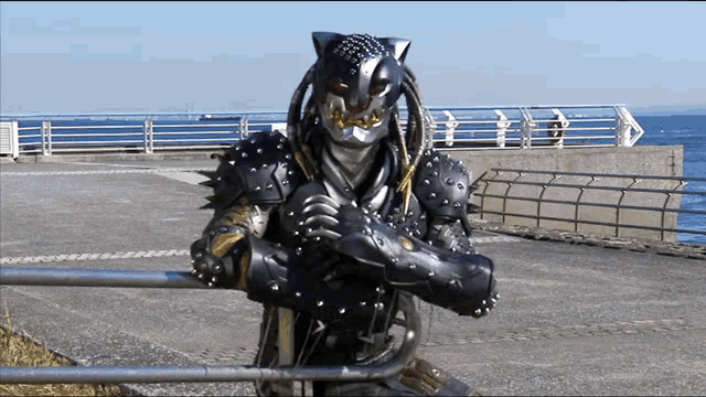 a person in a predator costume is standing on a sidewalk