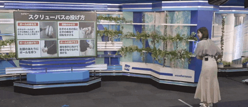 a woman is standing in front of a weather news sign