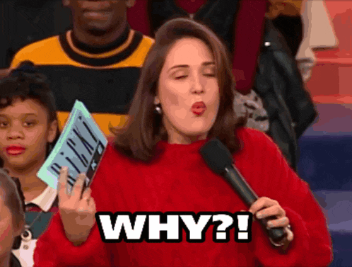 a woman in a red sweater holds a microphone and says " why "