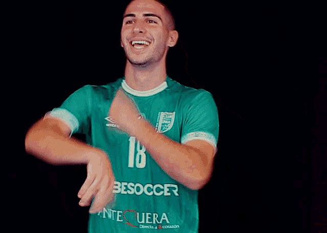 a man wearing a green shirt that says 18 on it
