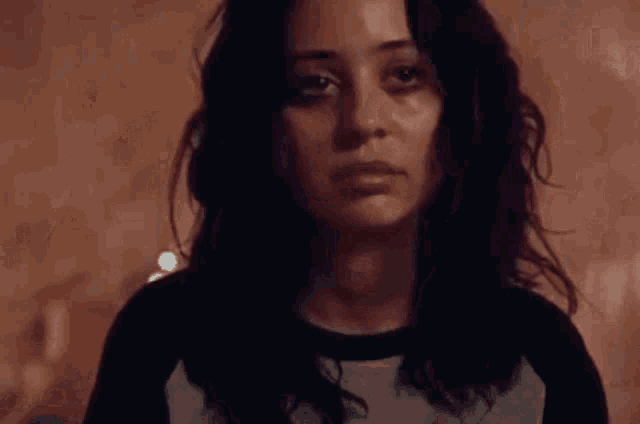a close up of a woman 's face in a dark room with a blurred background .