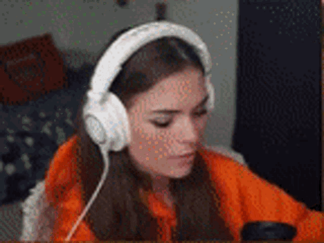 a woman is wearing headphones while sitting in front of a computer .