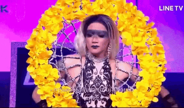 a woman in a black and white dress is surrounded by yellow flowers on a stage .