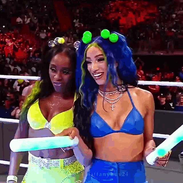 a couple of women standing next to each other in a ring