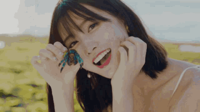 a woman is holding a blue crab in her hands