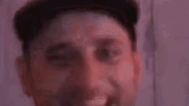 a close up of a man 's face with his eyes closed and a beard .