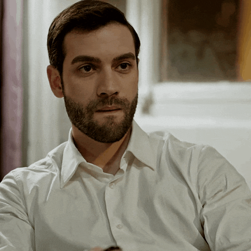 a man with a beard in a white shirt