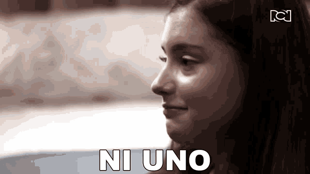 a close up of a woman 's face with the words ni uno written in white letters