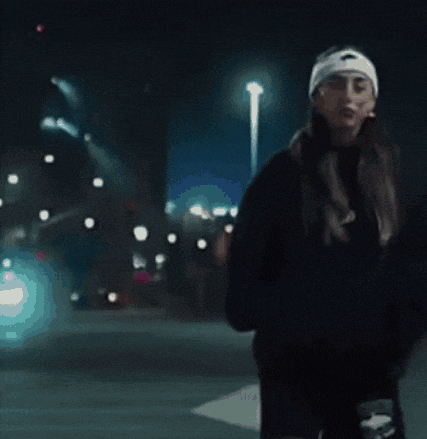 a woman wearing a nike hat is walking down the street