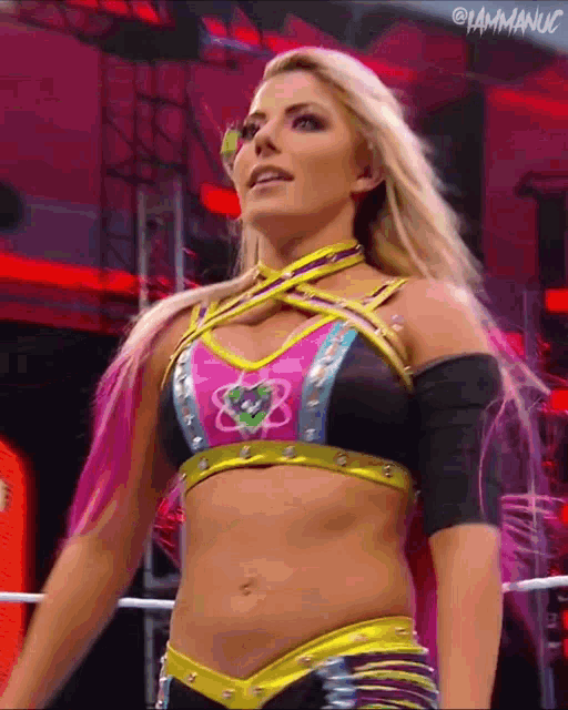 a female wrestler is standing in a ring wearing a crop top with the letter b on it