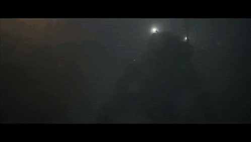 a man in a helmet is holding a flamethrower in a dark room