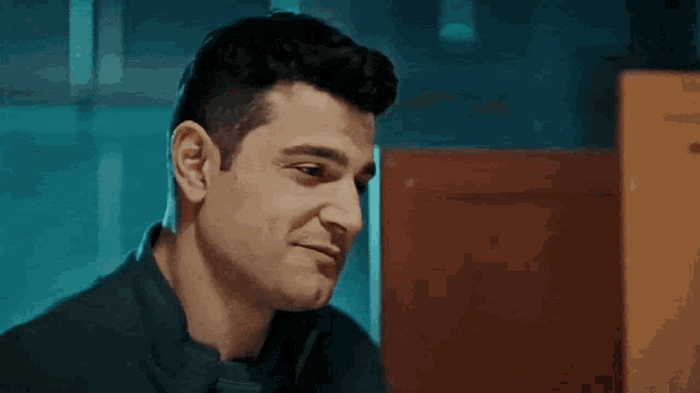 a man in a black shirt is talking on a phone