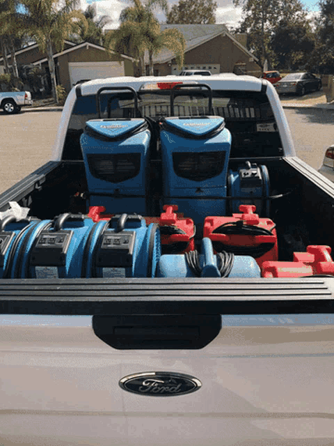 the back of a ford truck with a bunch of cleaning equipment