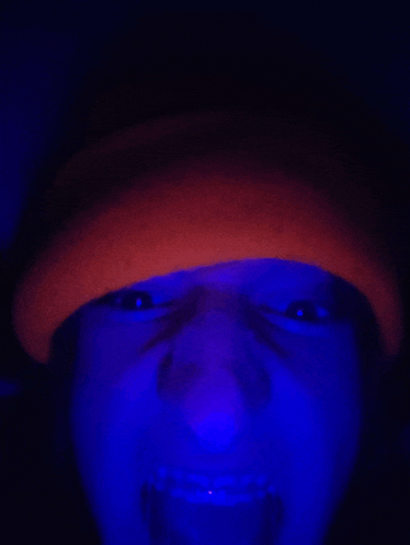 a person wearing a red hat is glowing in a blue light