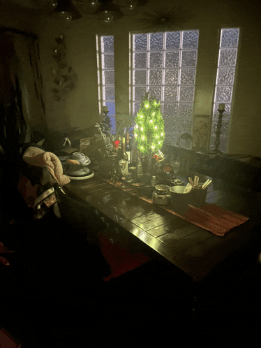 a christmas tree sits on a table in a dark room
