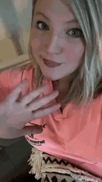 a woman wearing a pink shirt with the word marvel on the front