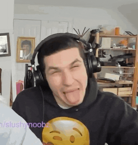 a man wearing headphones making a funny face with his tongue out .