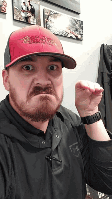 a man with a beard wearing a red hat that says ' eagles ' on it