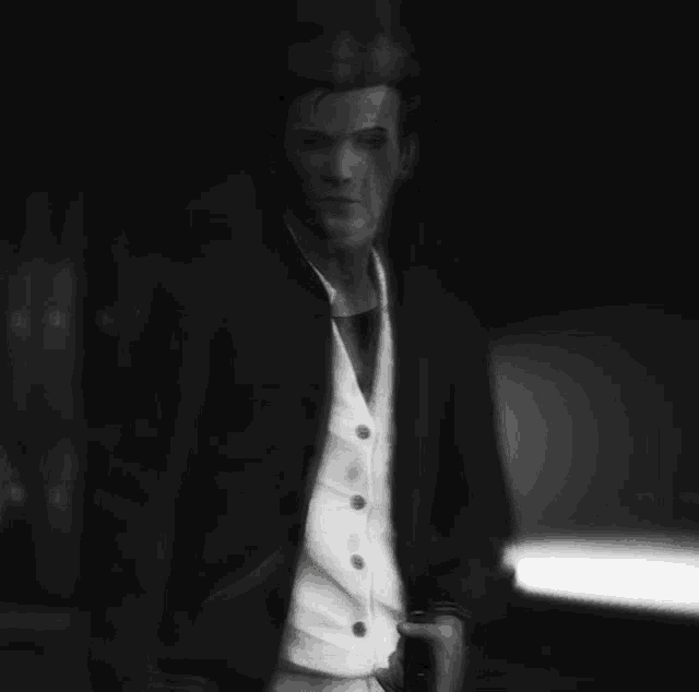 a black and white photo of a man in a suit holding a flashlight