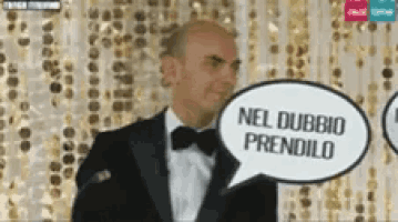 a man in a tuxedo has a speech bubble that says nel dubbio prendilo on it