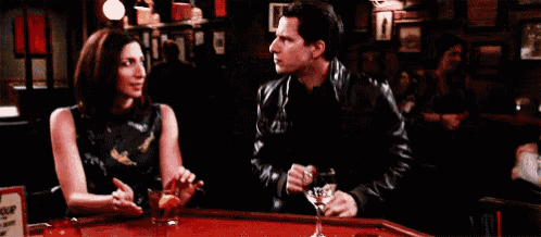 a man and a woman are sitting at a bar with a sign that says happy hour .