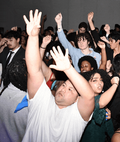 a man in a white shirt is dancing in a crowd
