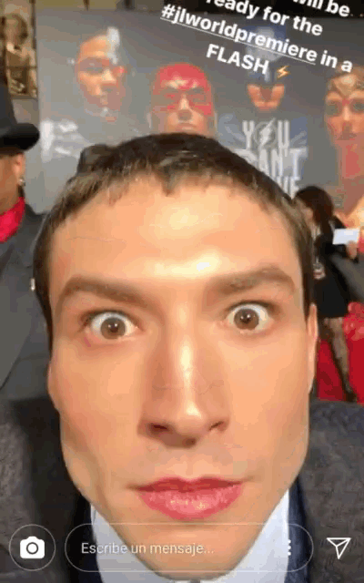 a man taking a selfie in front of a poster that says #jlworldpremiere in a flash