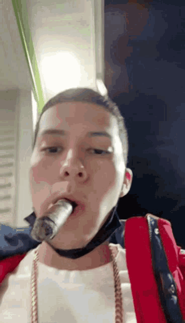 a man wearing a red jacket and a white shirt is smoking a cigar