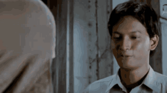 a man in a white shirt looks at another man