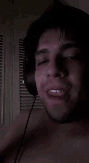a man without a shirt is wearing headphones