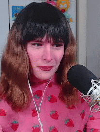 a woman wearing a pink sweater with strawberries on it