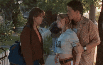 a man and two women are standing under a tree with a horseshoe on it