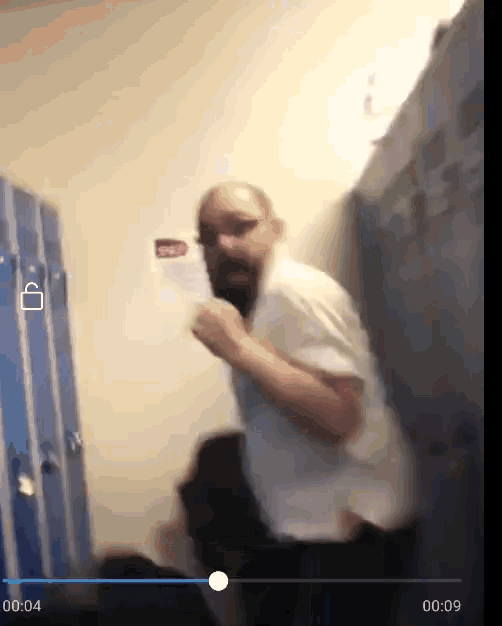 a man in a white shirt is standing in a locker room with a time of 00:44