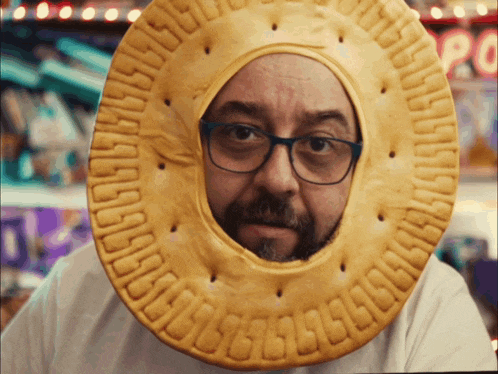 a man wearing glasses and a cookie on his head that says ' abcdefghijklmnopqrstuvwxyz ' on it