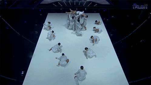 a group of dancers on a stage with the word talent on the bottom left