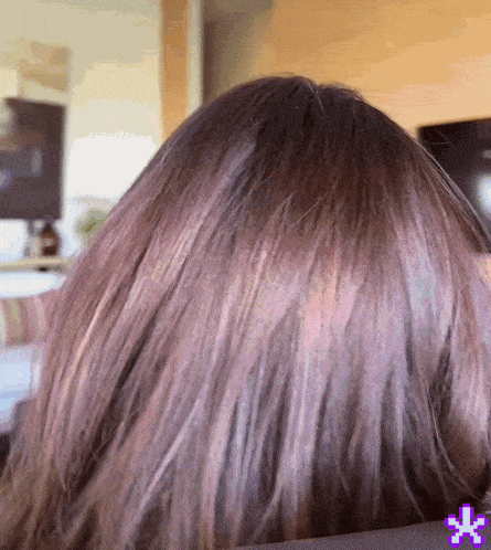 a close up of a woman 's hair with a purple pixel star in the corner