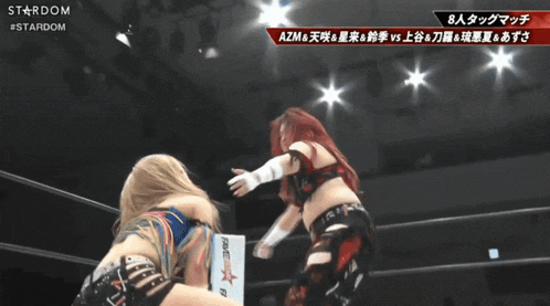 a female wrestler is kicking another female wrestler in the face during a stardom match