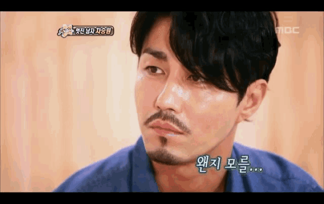 a close up of a man with a beard and korean writing on the bottom
