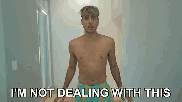 a shirtless man is standing in a hallway with the words i 'm not dealing with this behind him