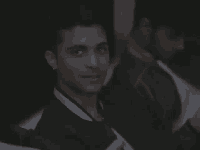 a man wearing a lanyard around his neck is smiling