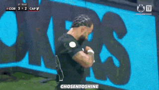 a man in a black jersey is running in front of a large blue sign that says chosentoshine