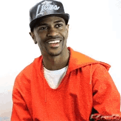 a man wearing a lions hat and a red hoodie smiles