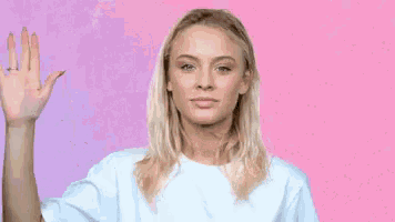a woman in a white shirt is waving her hand in the air .