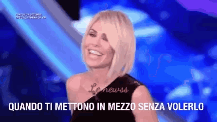 a woman is smiling in front of a blue background and the words quando ti mettono in mezzo senza volerlo