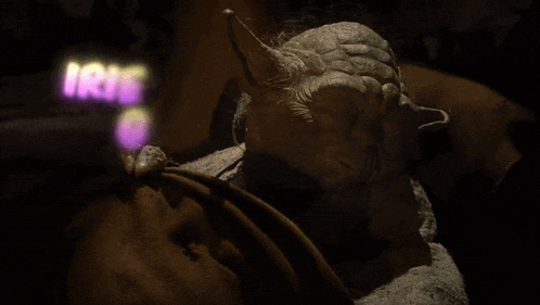 a picture of a statue of yoda with the words " irie yoda go "