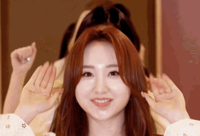a woman with red hair is making a funny face with her hands